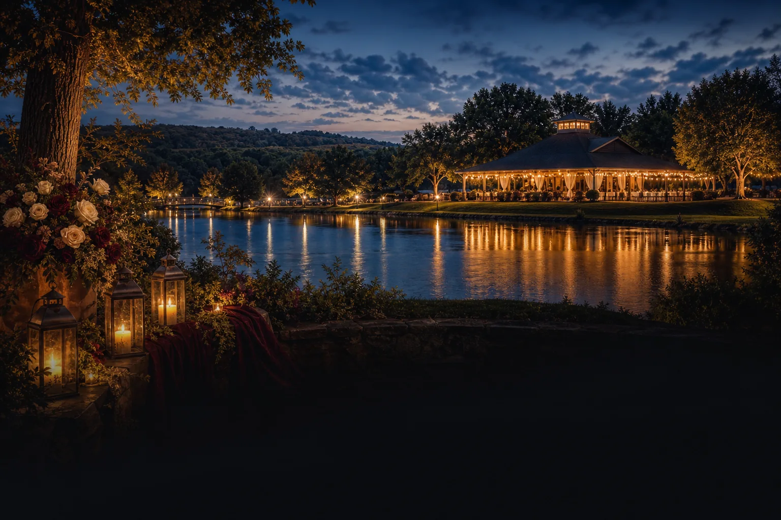 Lit lanterns and floral arrangements by a tranquil lake, with an illuminated pavilion reflecting on the water at dusk.