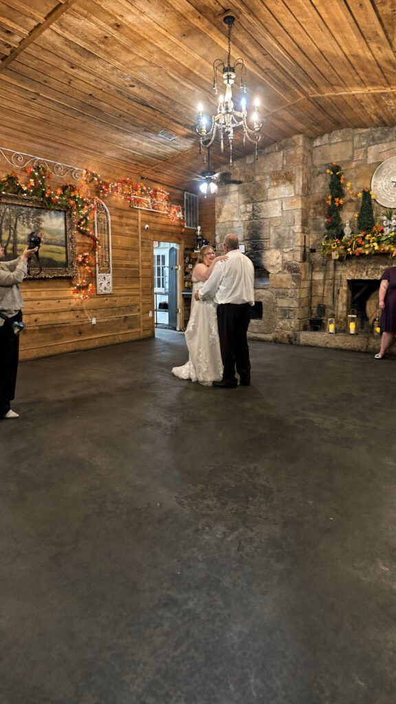 Princeton Kentucky Wedding DJ 12 Bride and groom dancing in a rustic room with wood-paneled walls and a stone fireplace