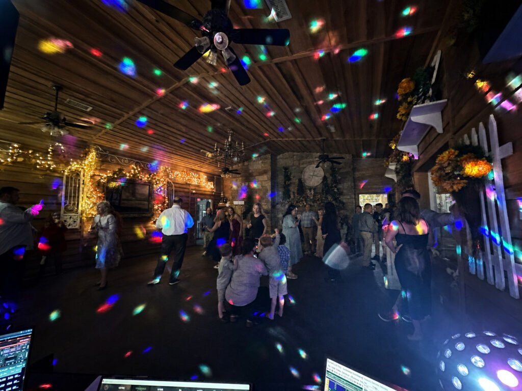 Princeton Kentucky Wedding DJ 13 People dancing in a rustic room illuminated by colorful disco lights