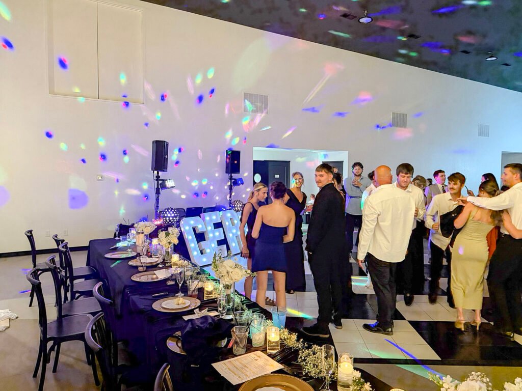 Guests socializing on the dance floor beside a decorated banquet table at a Highbanks reception.