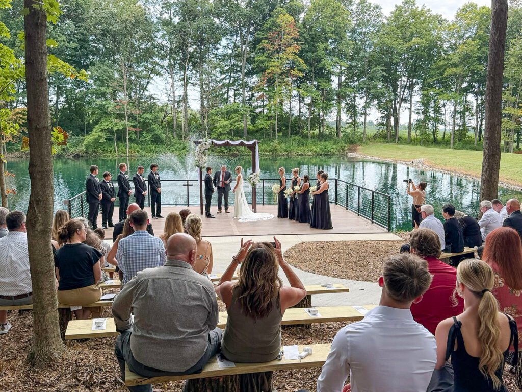 Outdoor waterside wedding ceremony on a wooden platform at Highbanks Wedding & Events in Petersburg, Indiana.