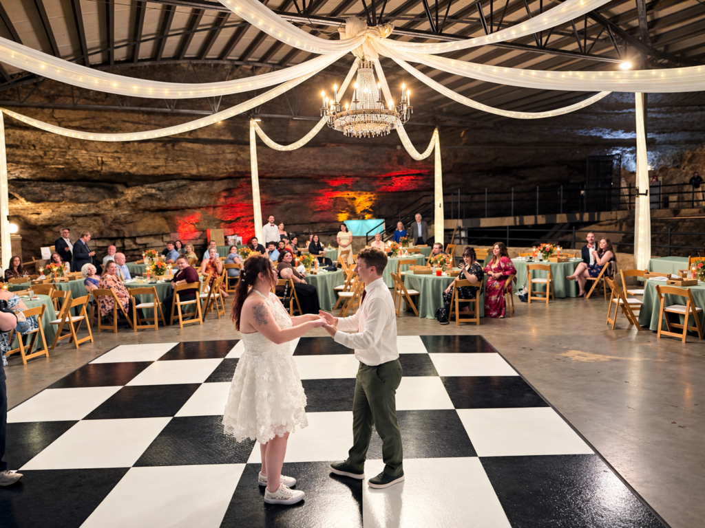 Bowling Green Kentucky Wedding DJ 1 Newlyweds dance on the black-and-white checkered floor at their Lost River Cave wedding reception in Bowling Green, KY
